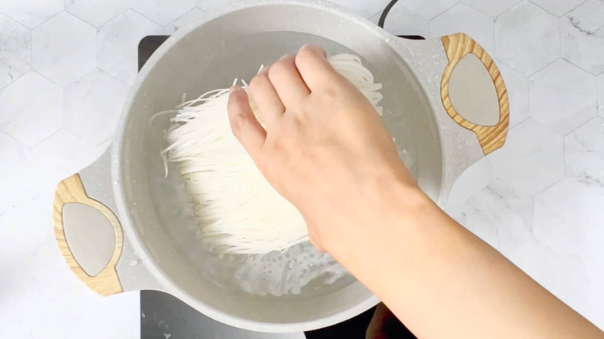 adding rice stick noodles to boiling water