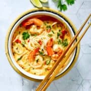 tom yum noodle soup in a bowl with chopsticks
