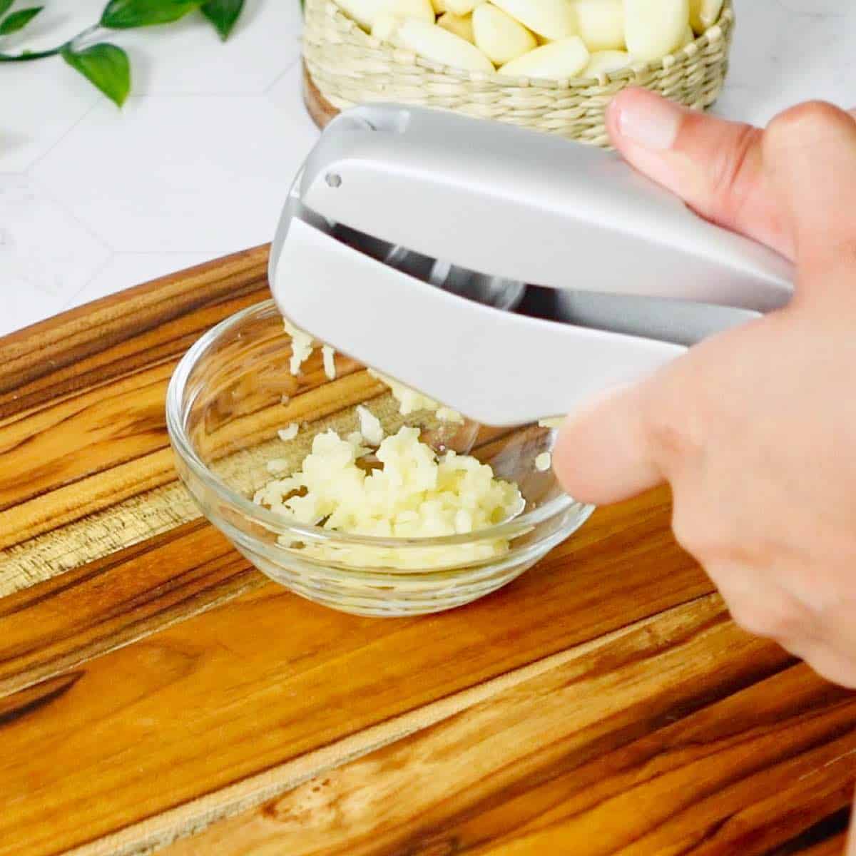 Peeling and mincing garlic in one step with a garlic press.