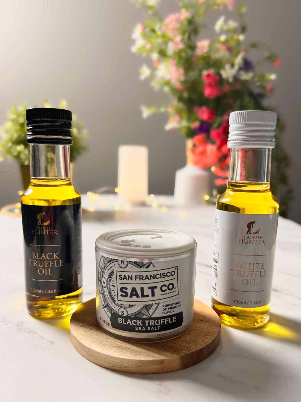 bottles of white and black truffle oil, and a jar of truffle salt placed together