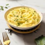 a plate of creamy and rich truffle mashed potatoes, garnished with parsley, placed on a table
