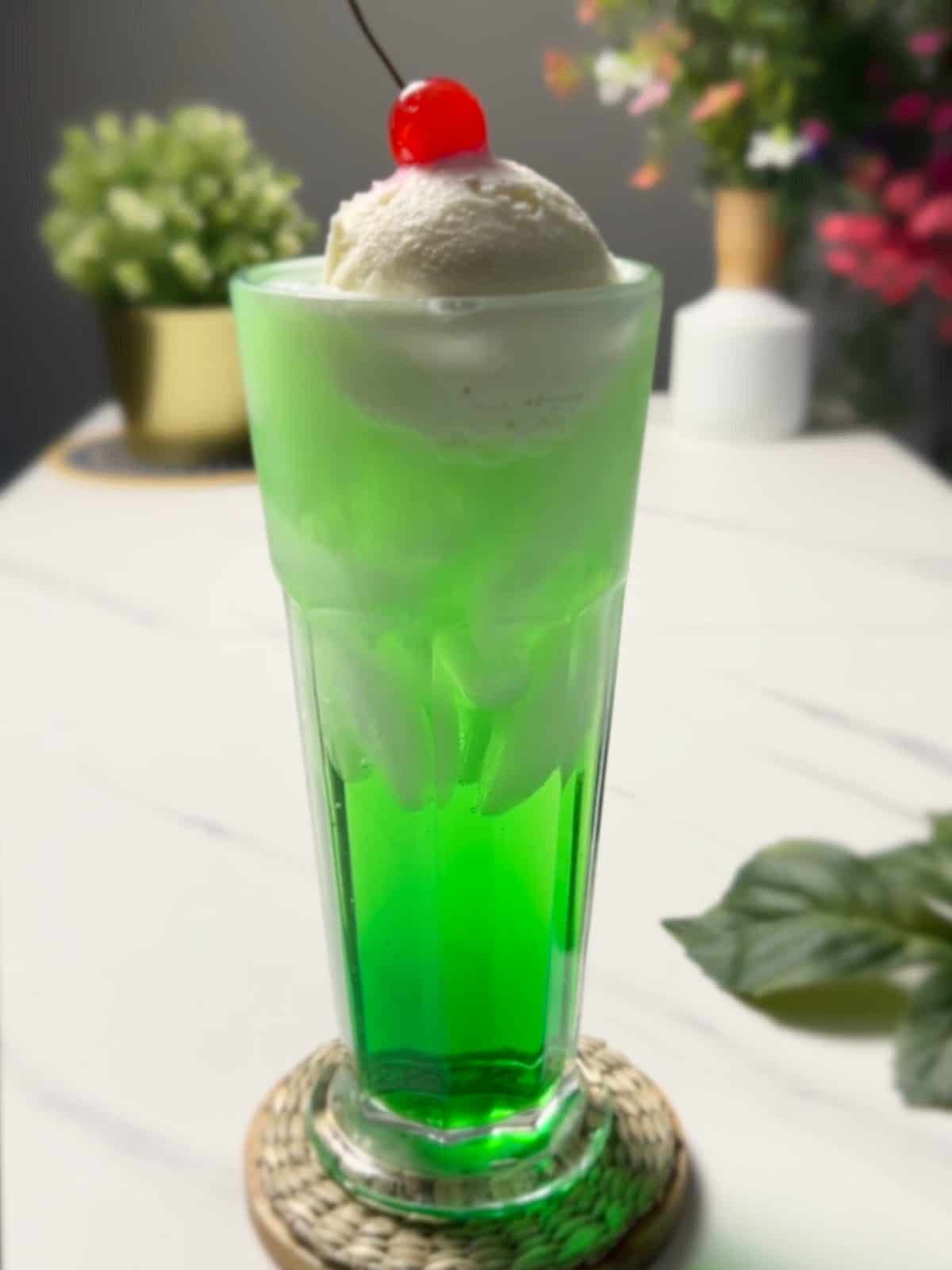 a tall glass of Japanese melon cream soda, complete with a scoop of vanilla ice cream and cherry on top