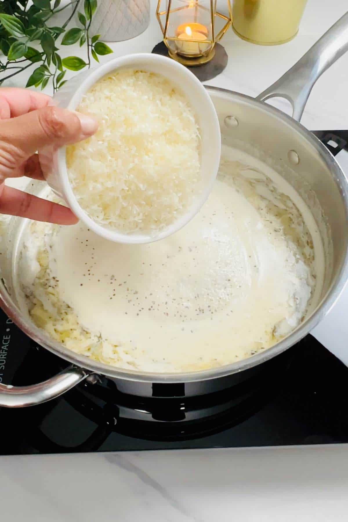 adding parmesan to the sauce in the skillet
