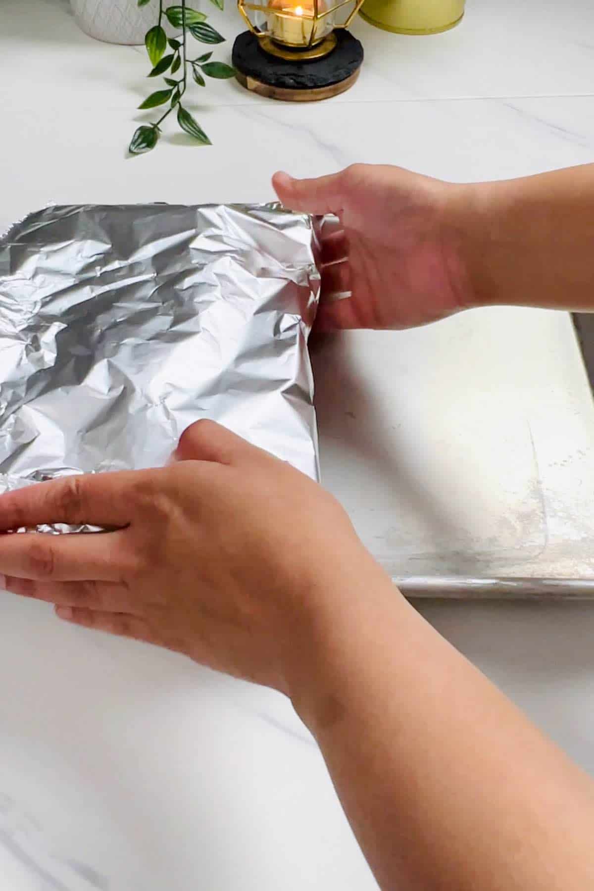 putting foil packets on a baking sheet