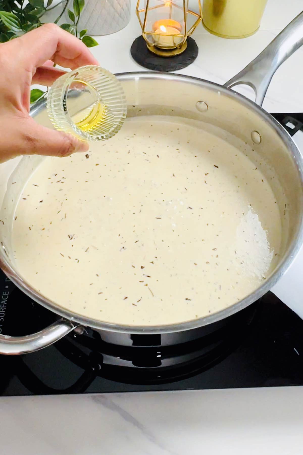 adding truffle oil to the cream sauce