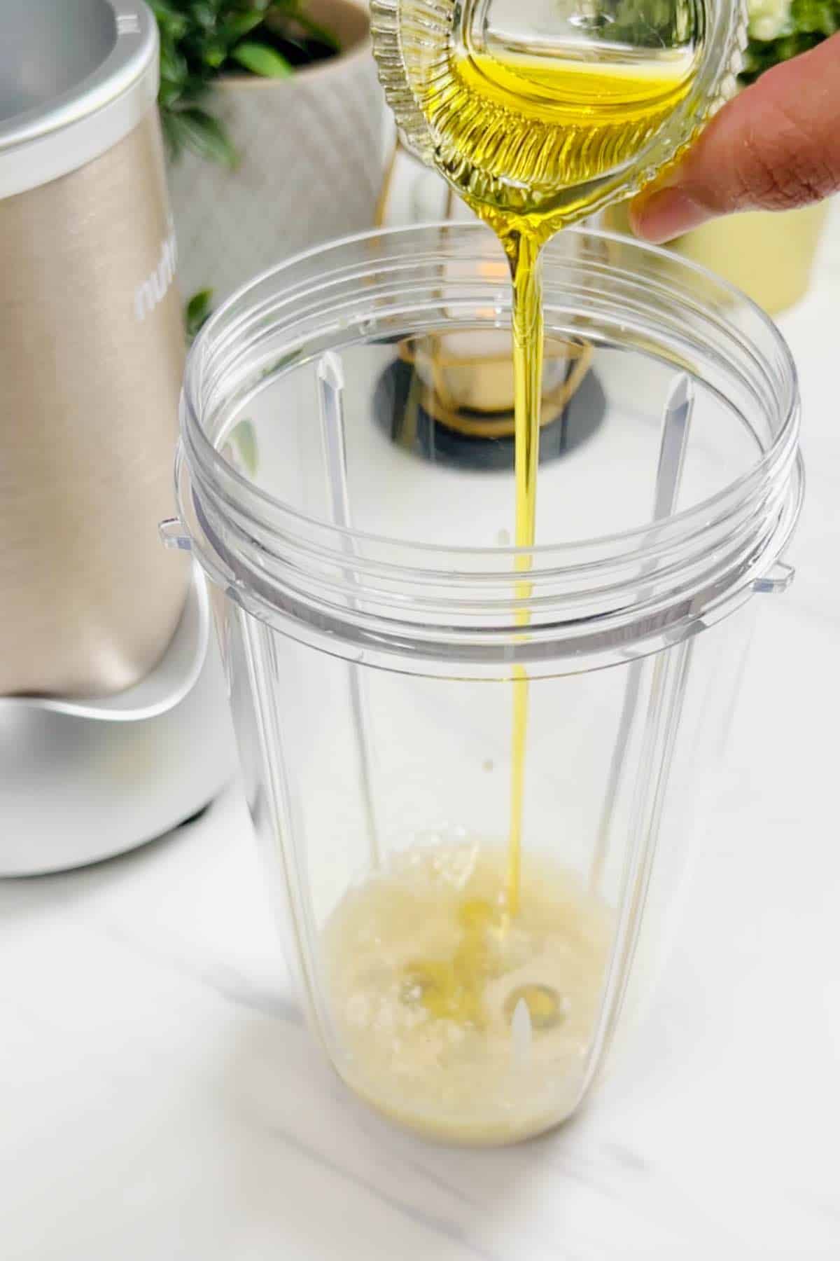 adding olive oil to a blender jar