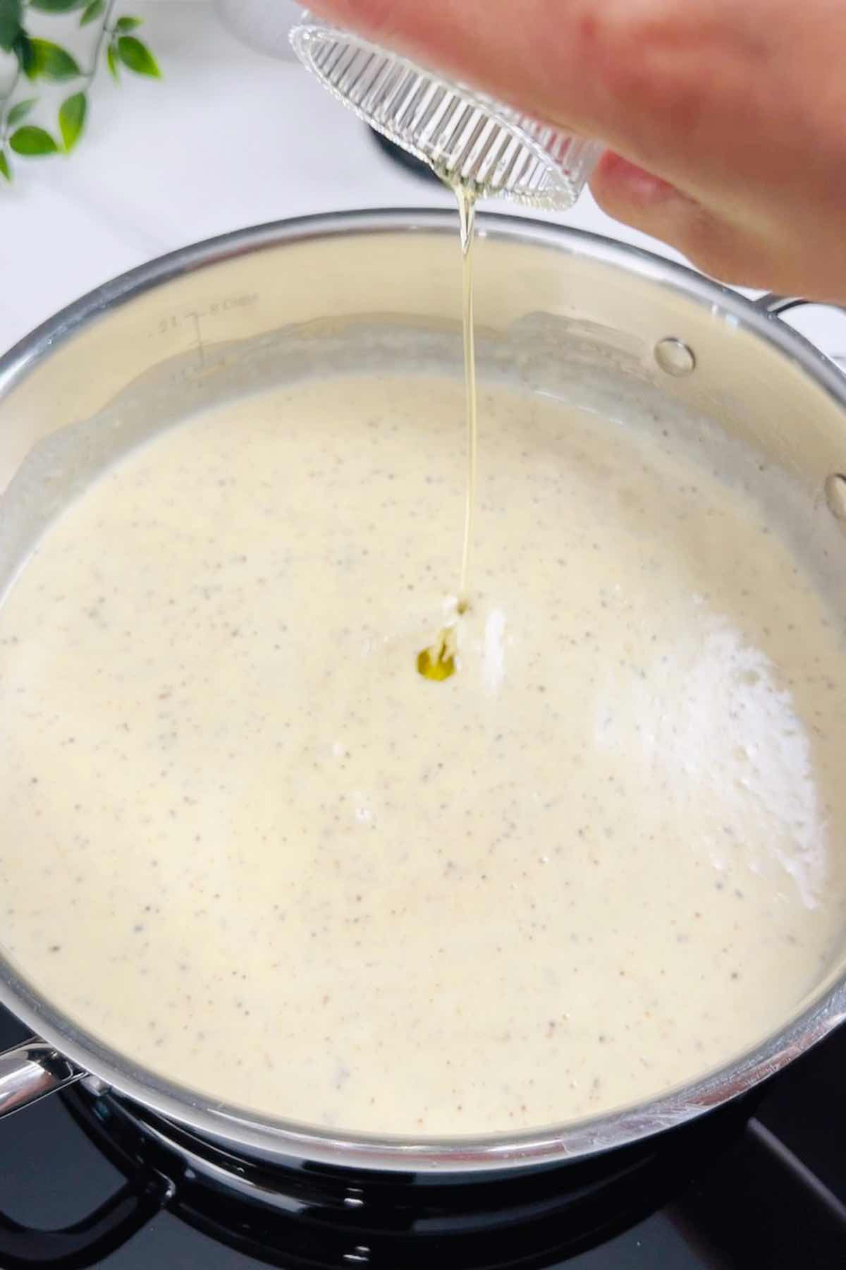adding truffle oil to the pasta sauce