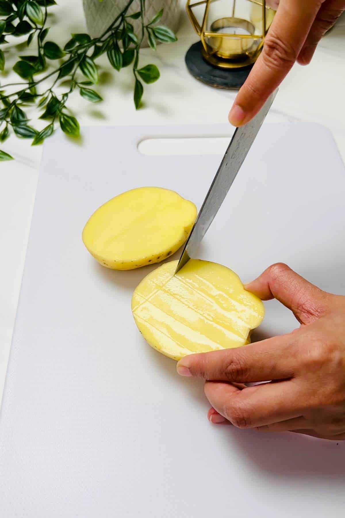 making a criss cross pattern on potatoes with a knife