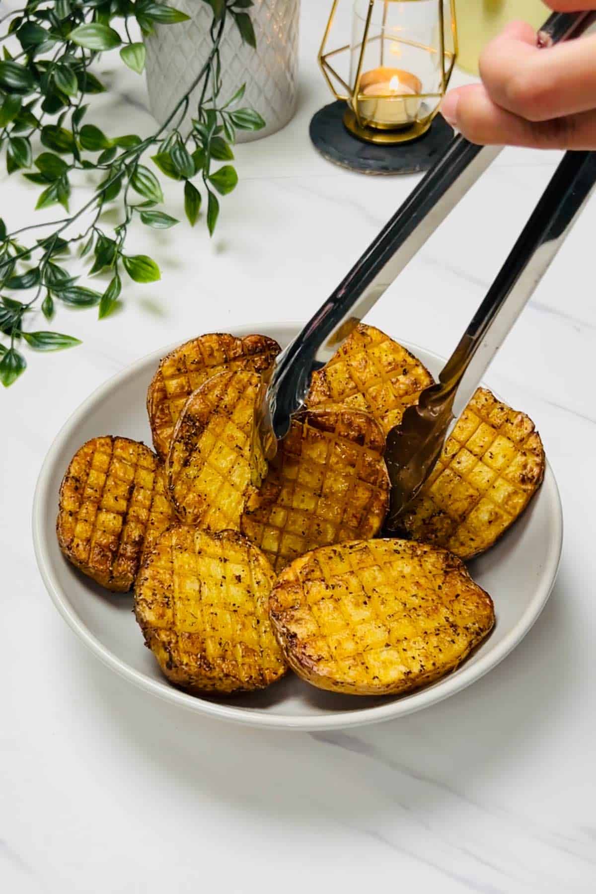 transferring cooked potatoes from air fryer to a plate