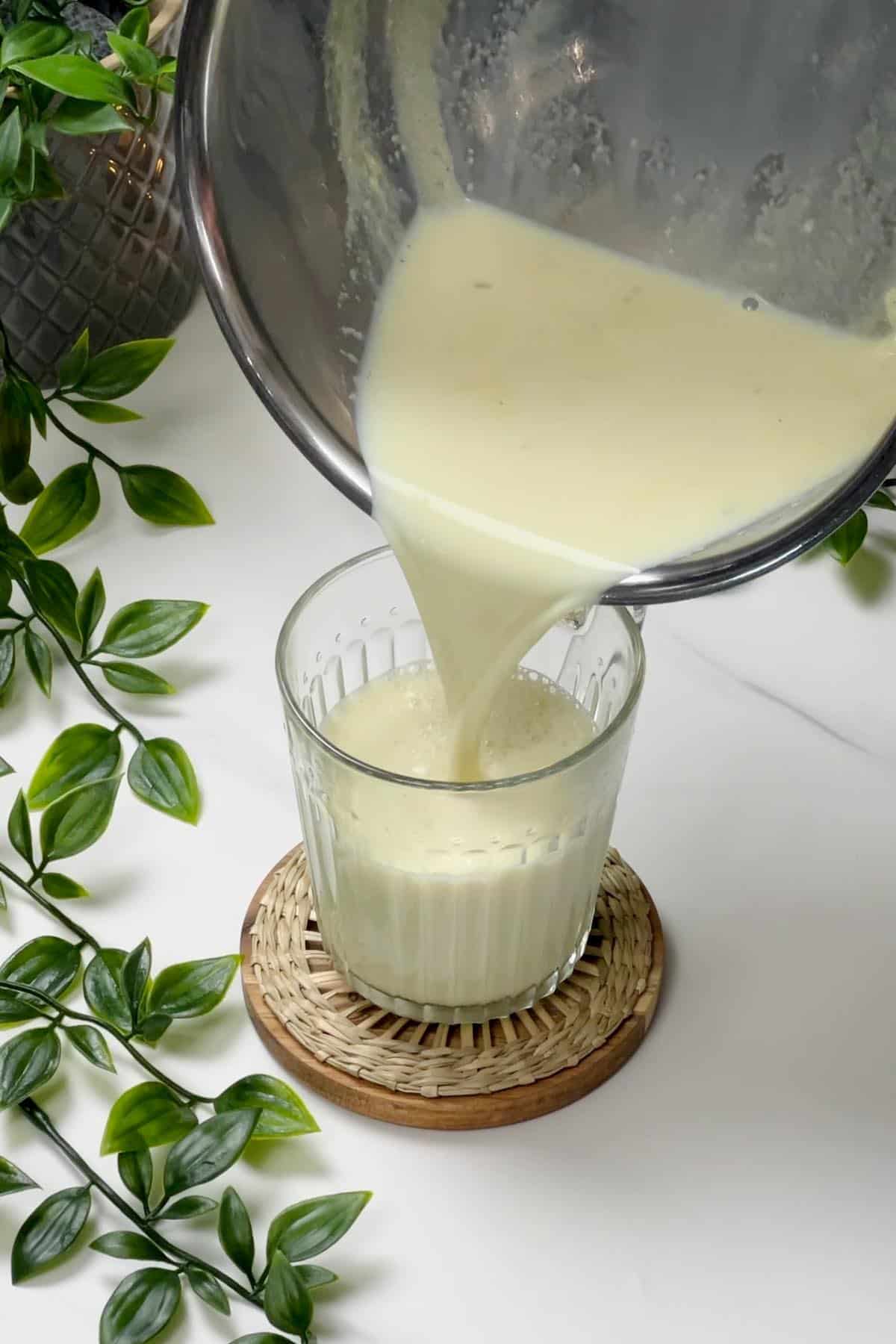 pouring cardamom milk into a cup