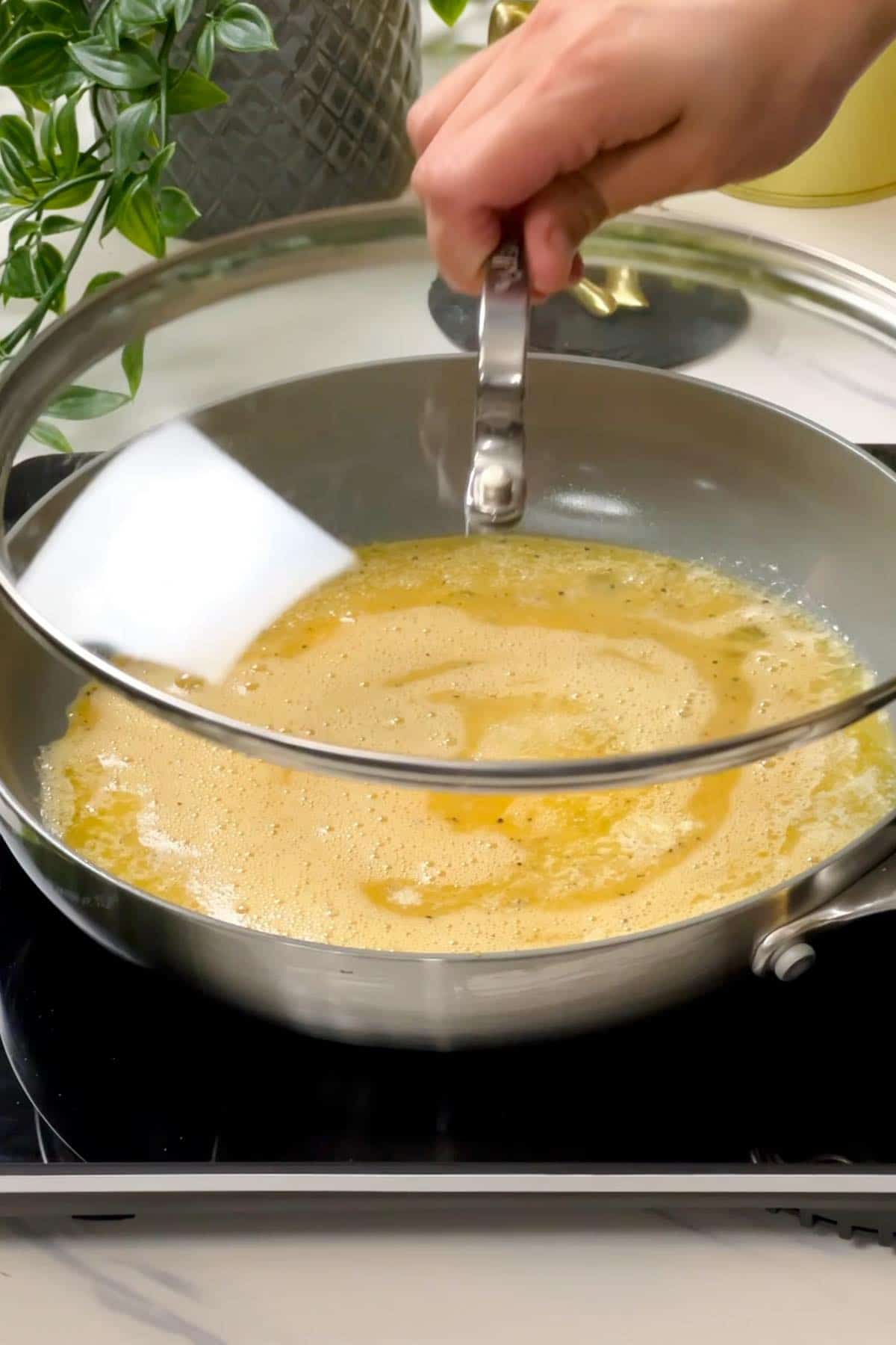 putting lid on the pan containing eggs