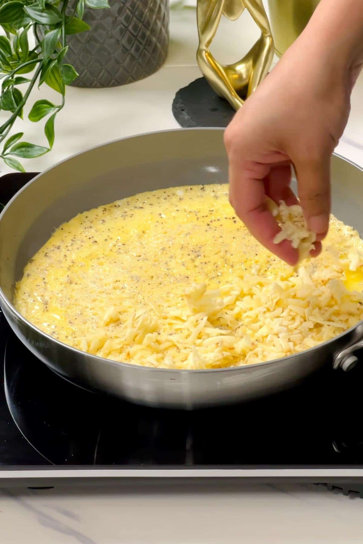 putting cheddar cheese on half of the omelette