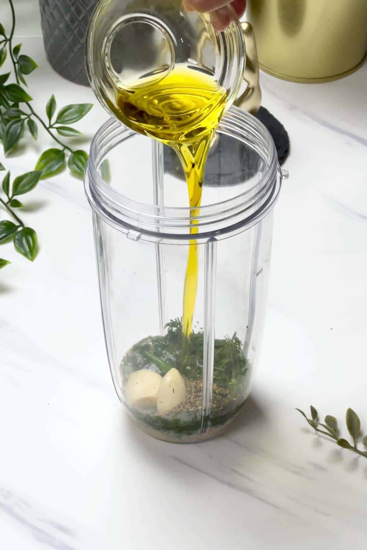 adding lemon juice, dill, oil and other ingredients to a blender jar
