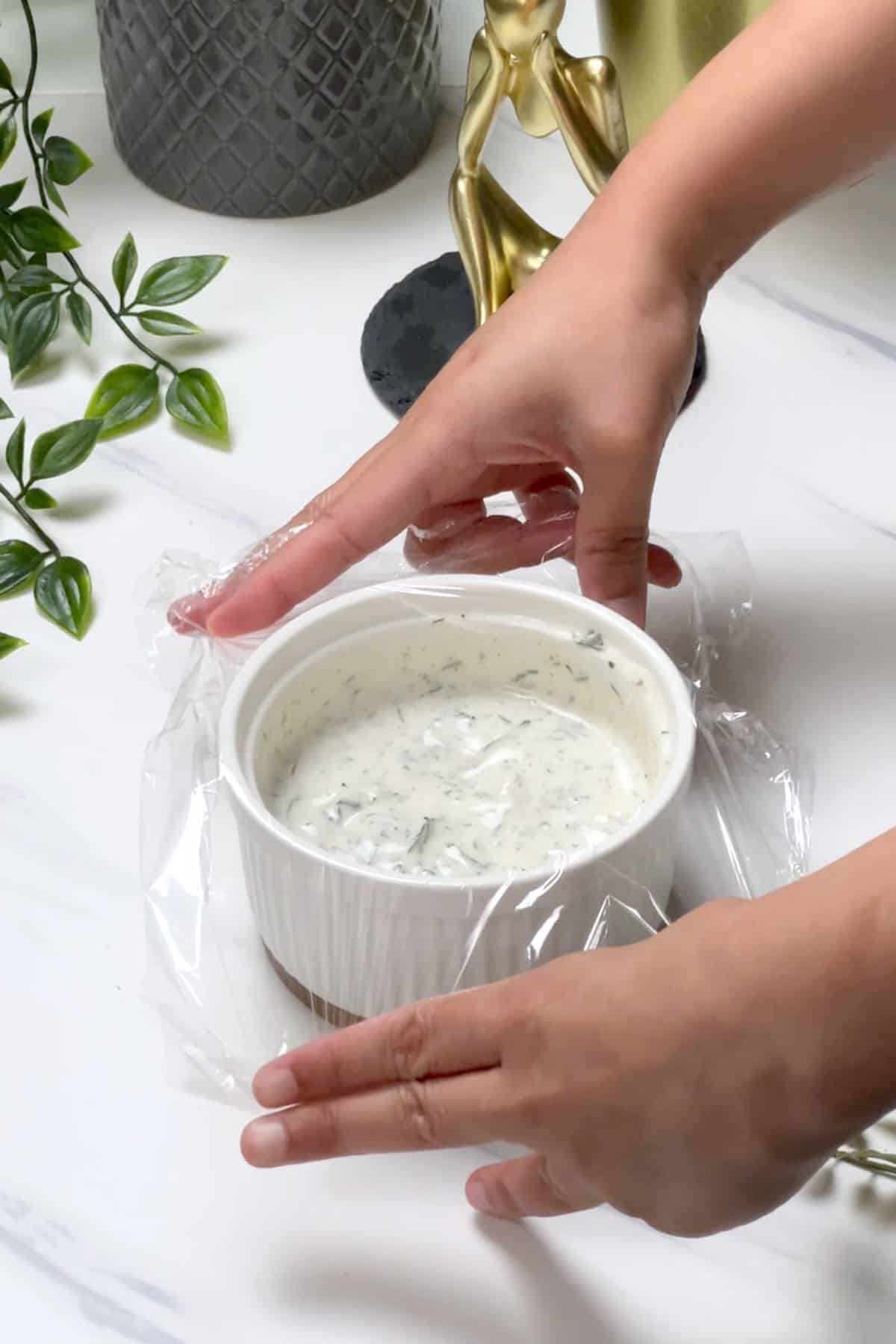 covering lemon dill sauce with plastic wrap