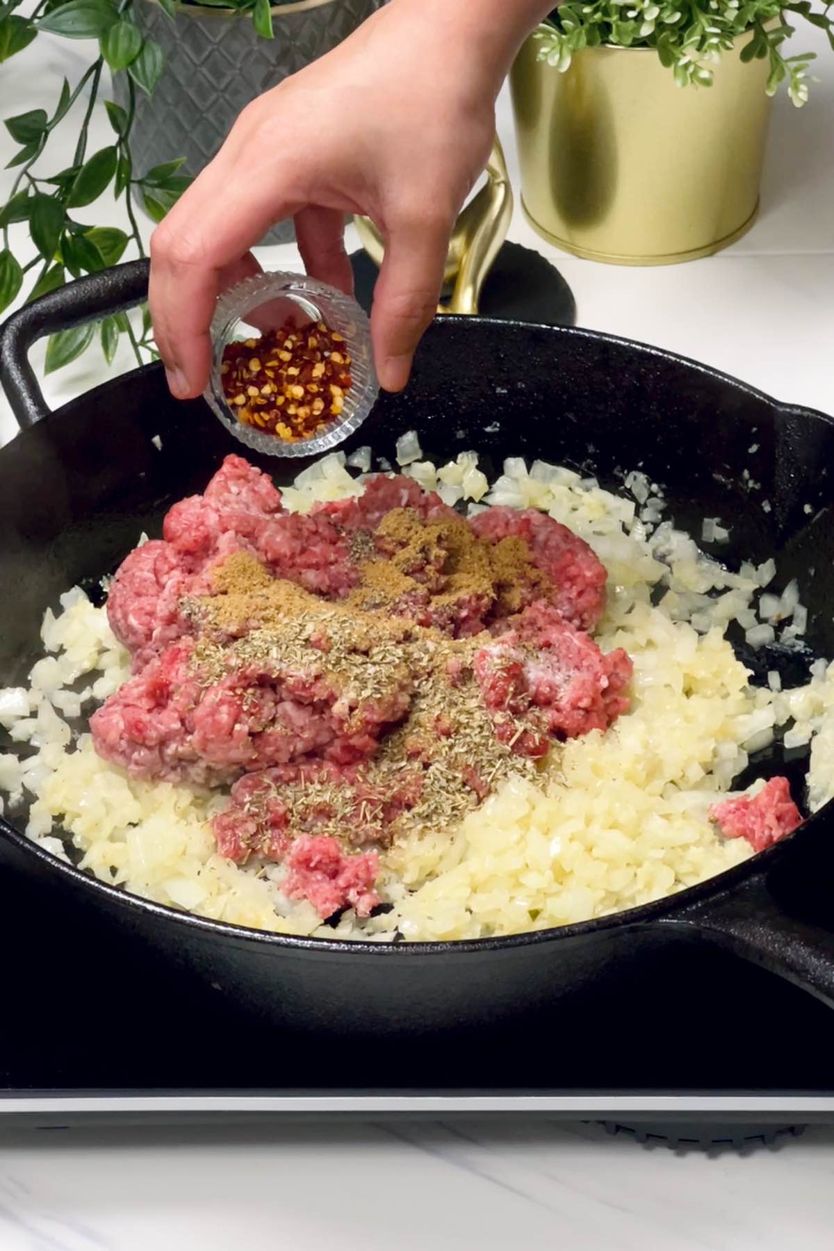 adding ground beef and seasonings to the skillet