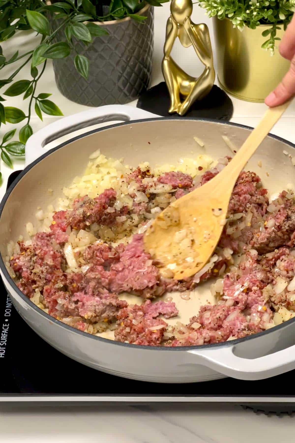 mixing ground beef and seasonings in the skillet