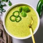 cream of jalapeno soup garnished with jalapeno slices and cilantro leaf