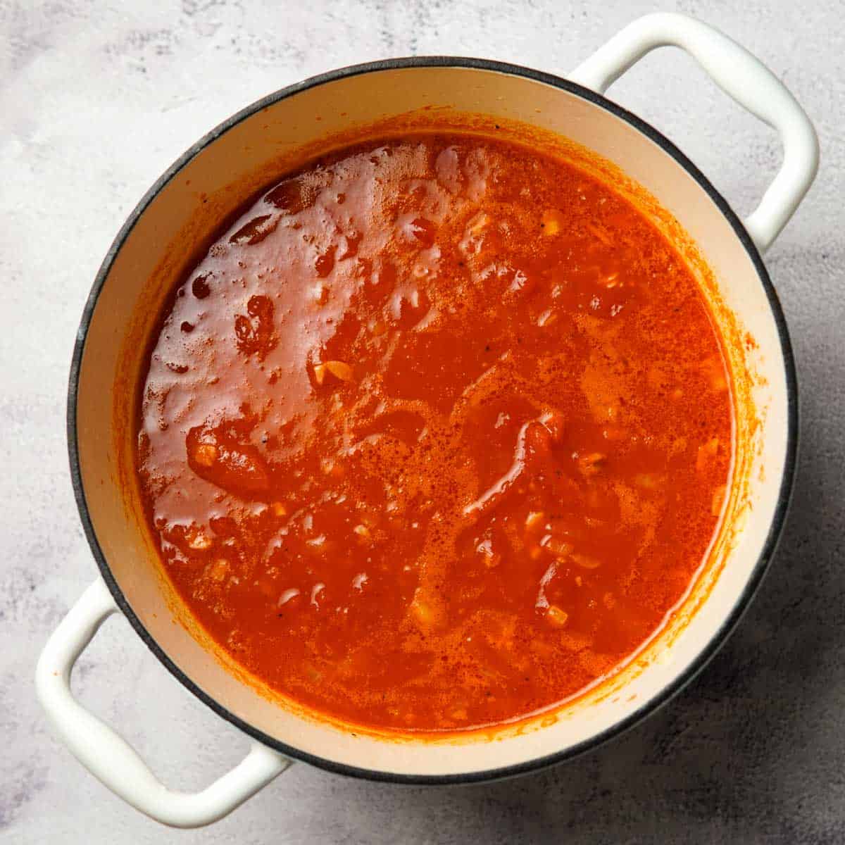 cooking tomato and broth along with garlic onion and seasonings