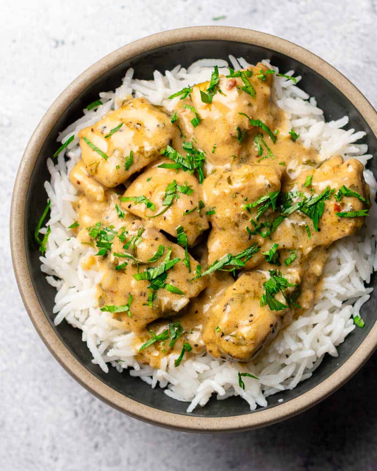 a bowl contain creamy garlic lime chicken on top of cooked white rice