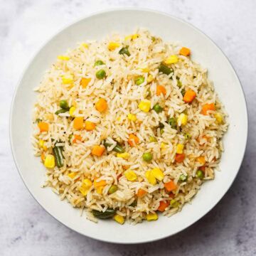 mixed vegetable rice with peas, carrots, corn and beans on a plate