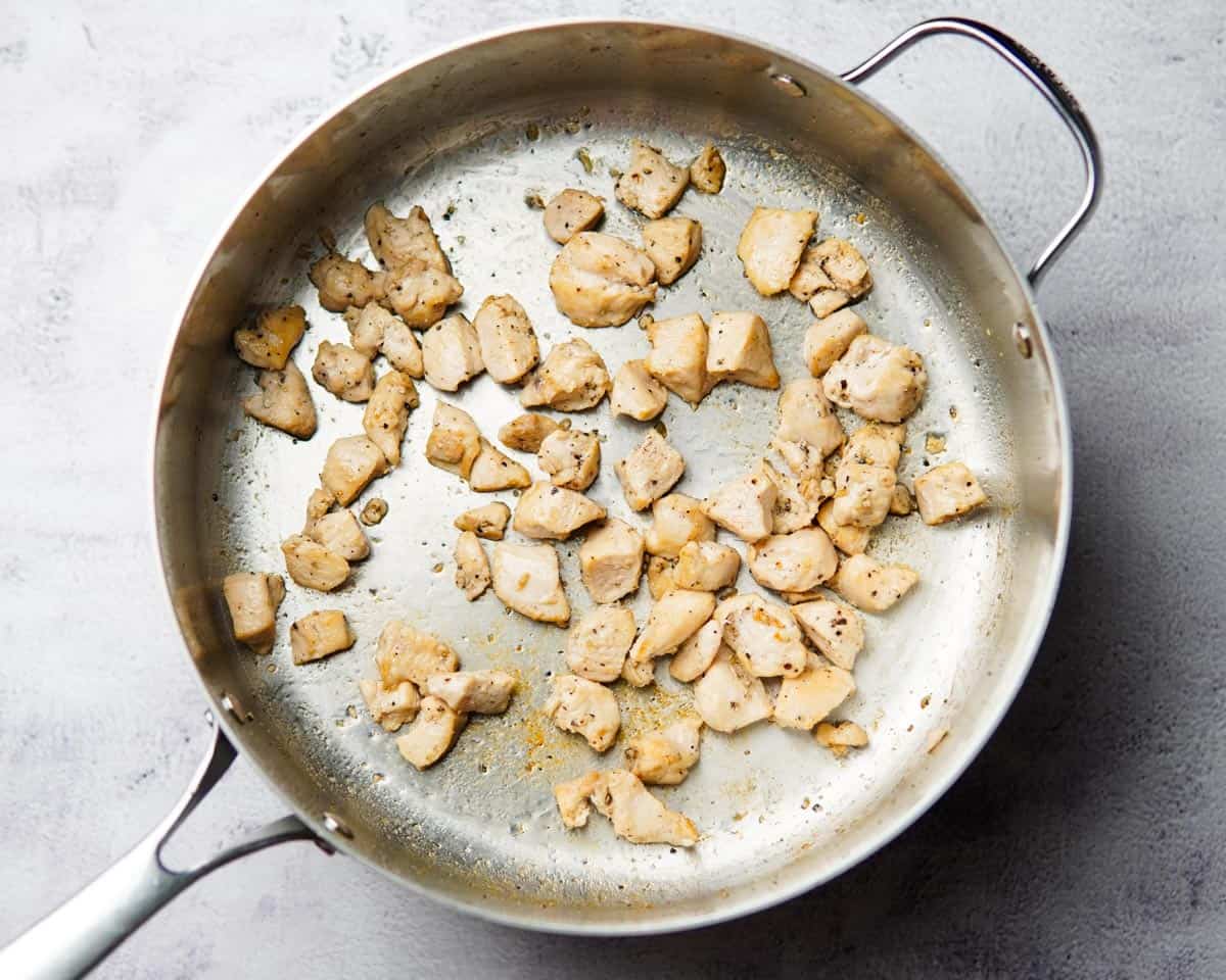 cooked diced chicken in a stainless steel pan