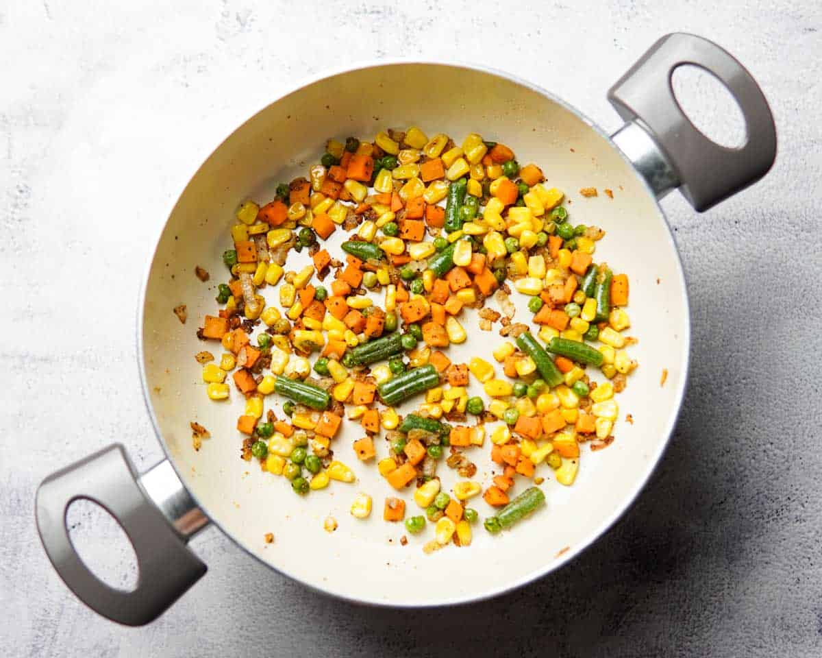 frozen corns, peas, carrots and beans cooking in a pan