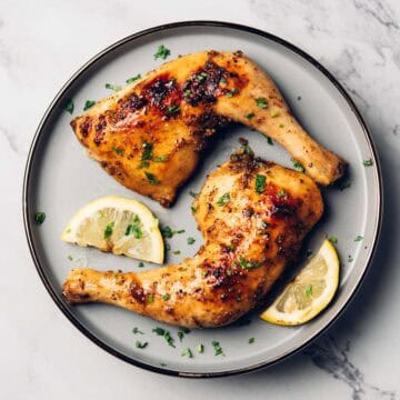 baked lemon pepper chicken leg quarters on a plate