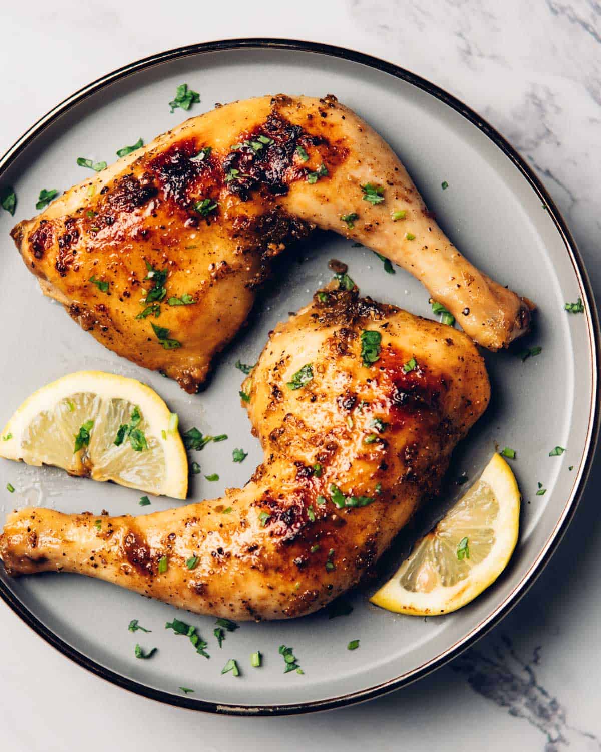 a plate containing baked lemon pepper chicken leg quarters