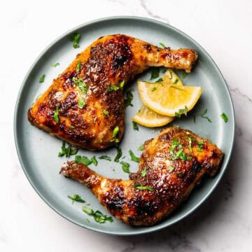 baked jamaican jerk chicken quarters on a plate
