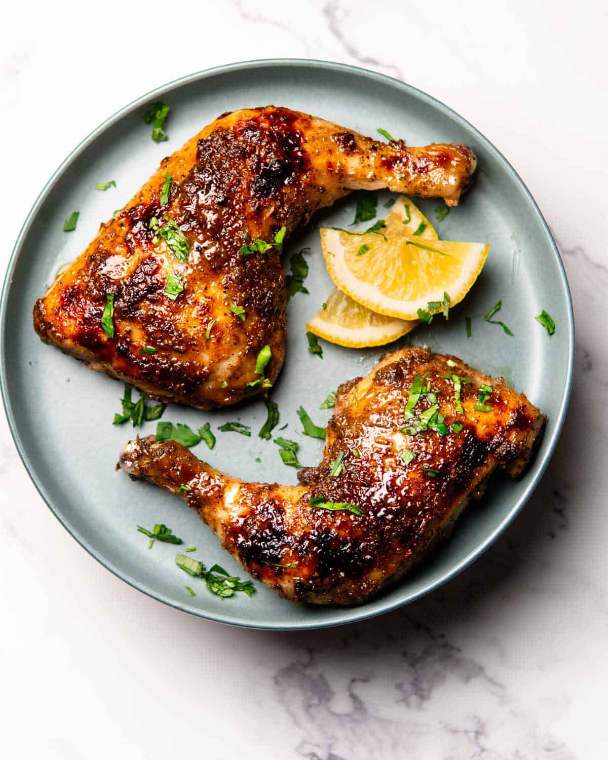 a plate containing baked jerk chicken leg quarters