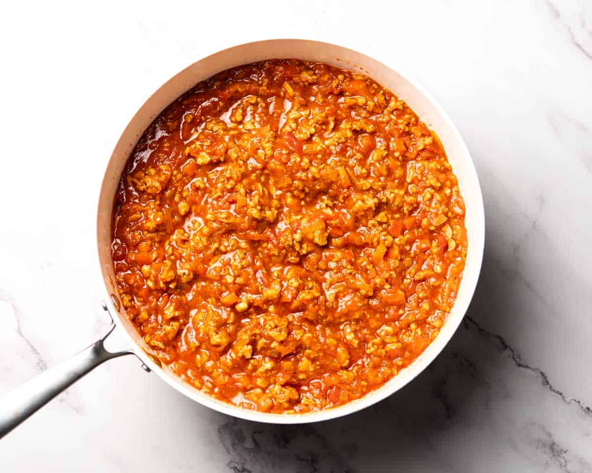 seasoned ground chicken and tomatoes simmering in a skillet