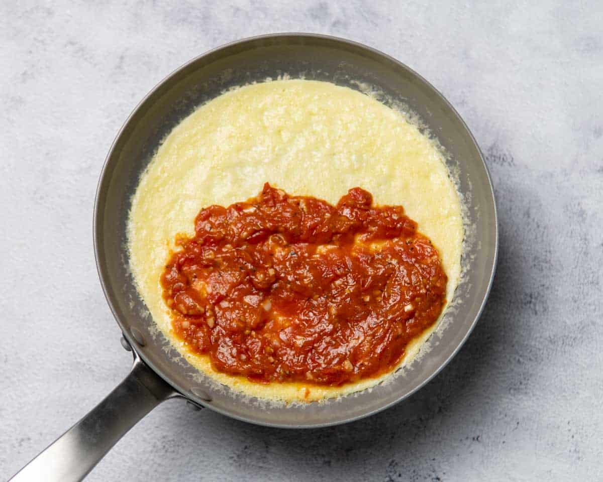 tomato reduction placed on one half of the omelette in a pan
