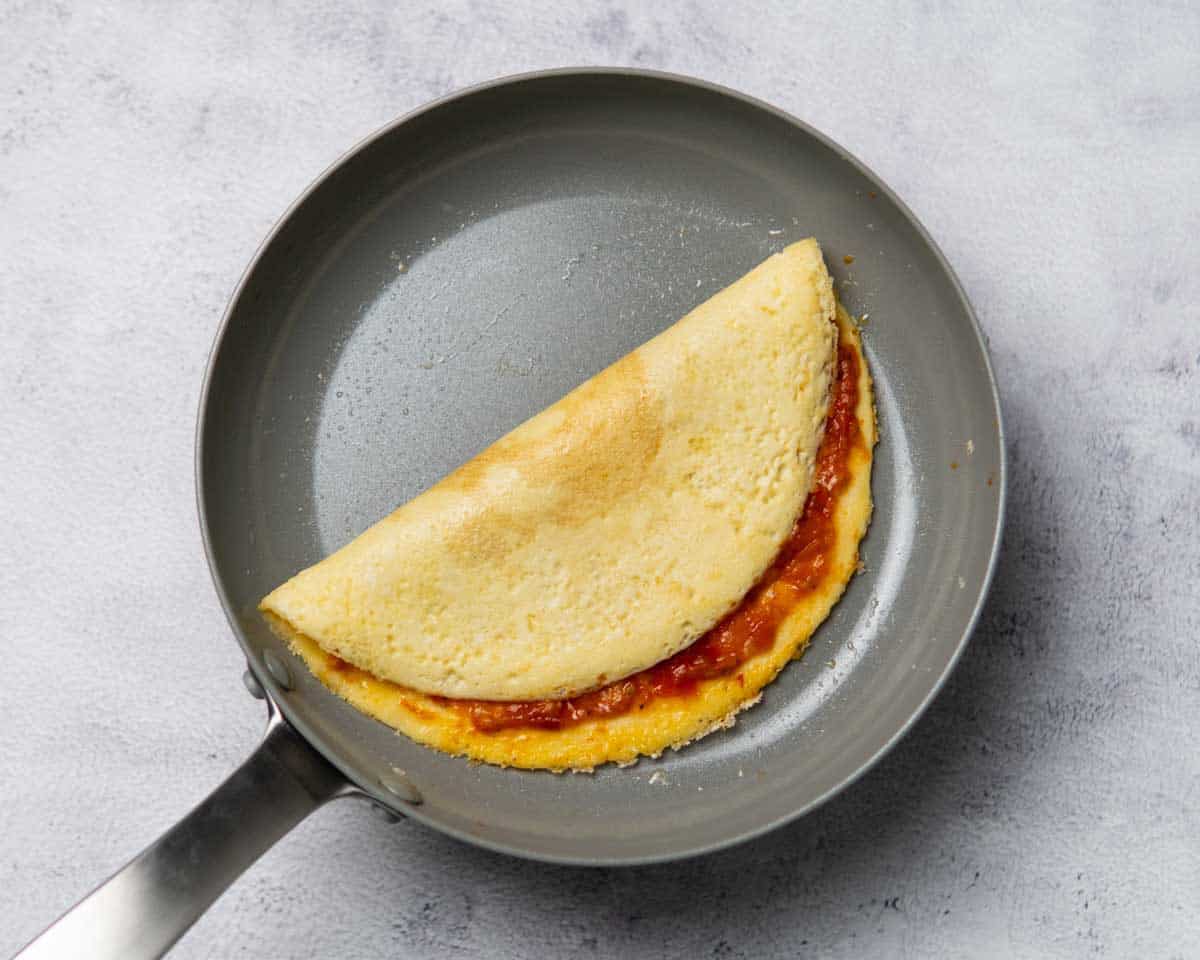 folded tomato omelette in a pan