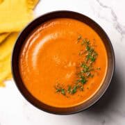 tomato dill soup in a bowl garnished with chopped dill