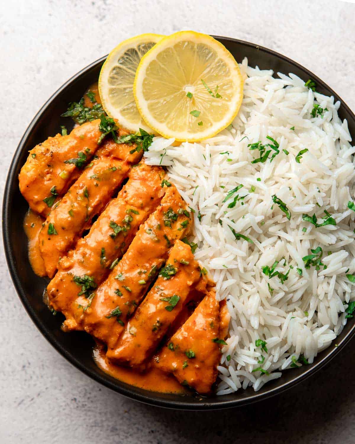 tomato chicken served on a plate with rice