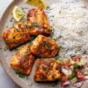 Indian style baked tilapia served on a plate with rice